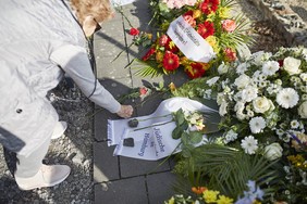 Mindu Hornick is laying down stones on the wreath from the Jewish community of Hamburg.